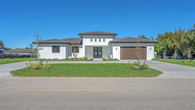 prairie-style house featuring a garage and a front yard