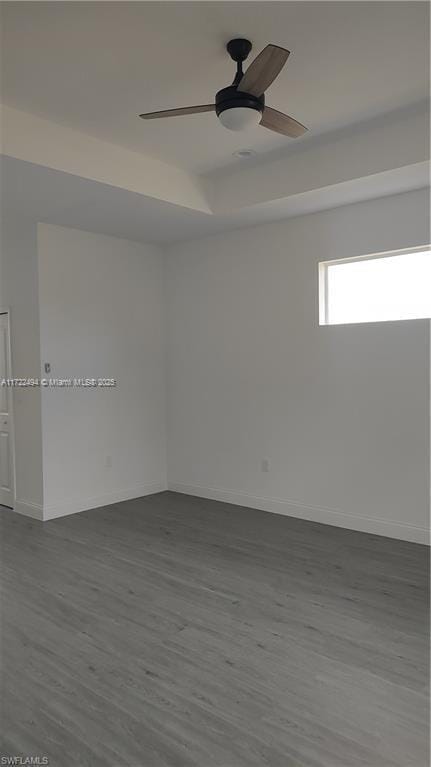 unfurnished room featuring hardwood / wood-style floors, a raised ceiling, and ceiling fan