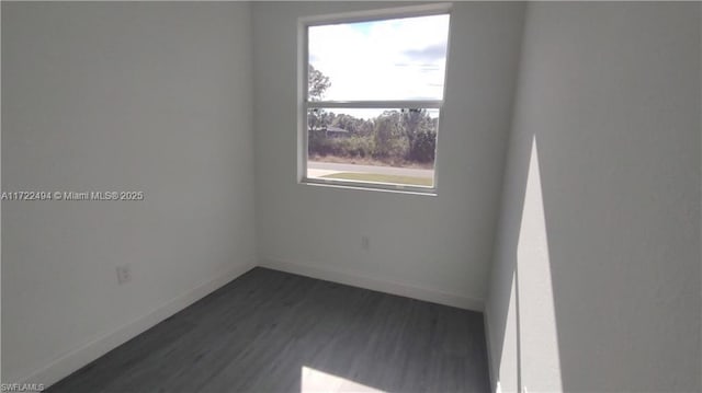 empty room featuring a wealth of natural light and dark hardwood / wood-style floors