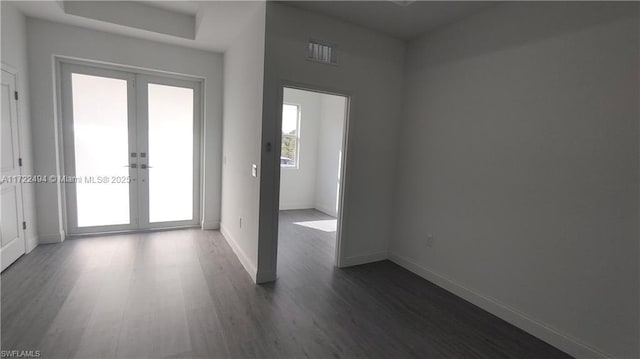 empty room with french doors and dark wood-type flooring