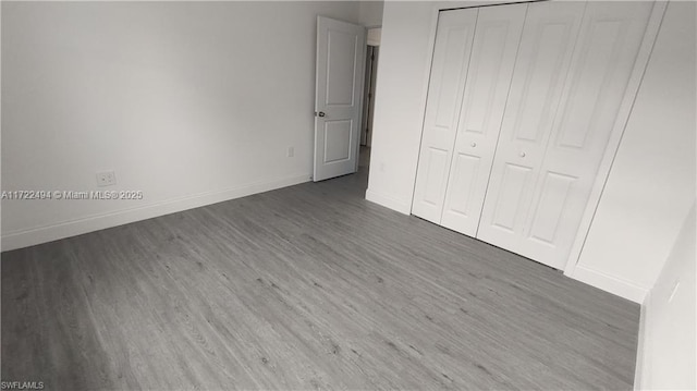 unfurnished bedroom featuring dark hardwood / wood-style flooring and a closet