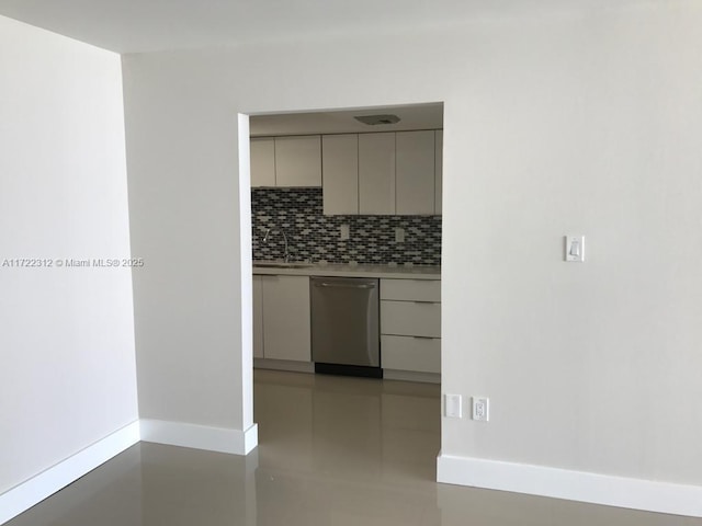 kitchen featuring backsplash, gray cabinets, sink, and stainless steel dishwasher