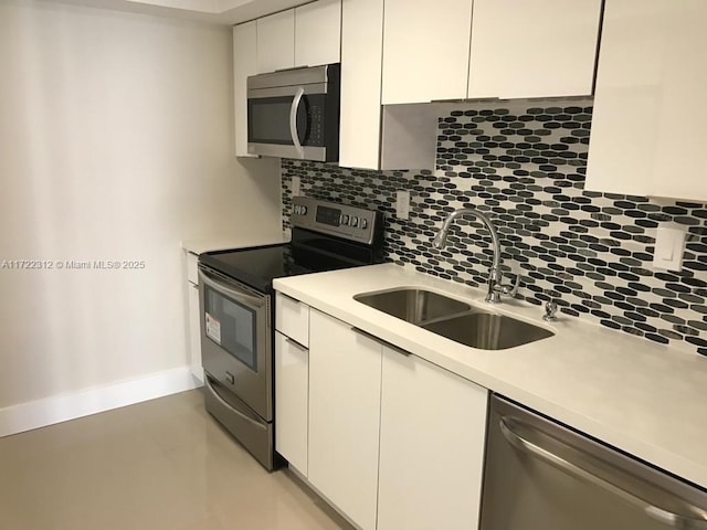 kitchen featuring white cabinets, appliances with stainless steel finishes, backsplash, and sink