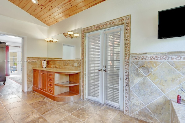 bathroom with lofted ceiling, vanity, wood ceiling, and tile walls