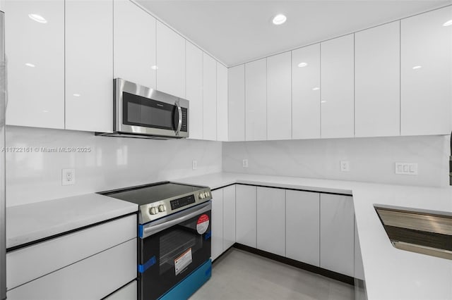 kitchen with tasteful backsplash, white cabinetry, and stainless steel appliances