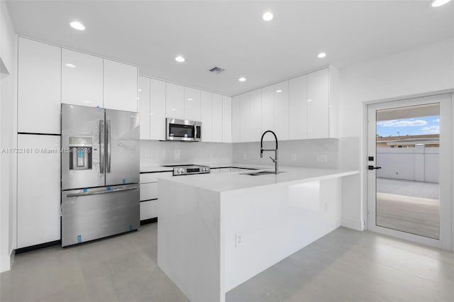 kitchen featuring white cabinets, sink, kitchen peninsula, and stainless steel appliances