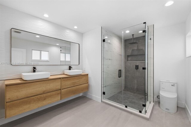 bathroom with tile patterned flooring, vanity, toilet, and walk in shower