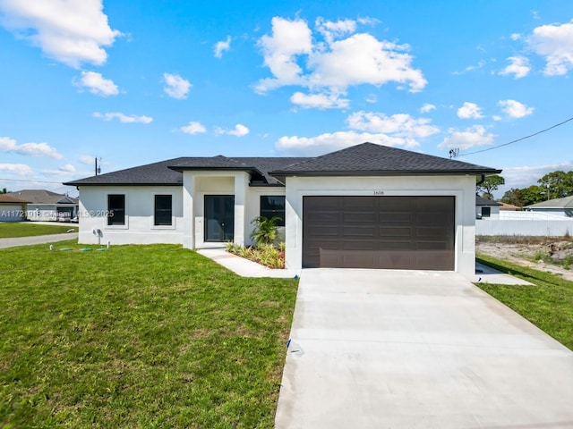 1608 Flora Ave S, Lehigh Acres, FL 33976 - prairie-style house featuring a garage, driveway, fence, a front lawn, and stucco siding