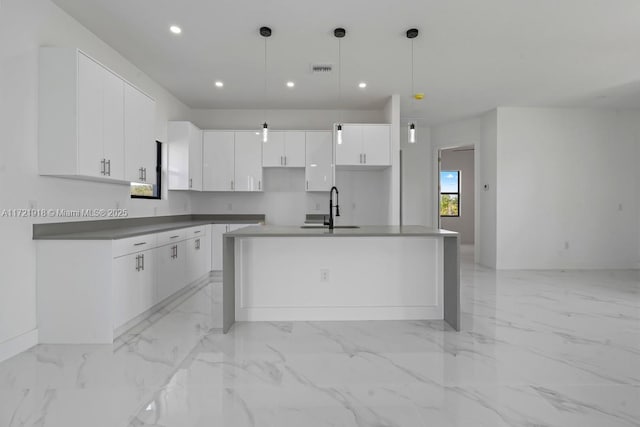 1608 Flora Ave S, Lehigh Acres, FL 33976 - kitchen with a kitchen island with sink, recessed lighting, a sink, white cabinetry, and marble finish floor