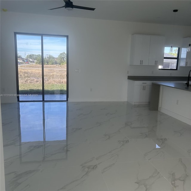 kitchen with white cabinets, decorative light fixtures, and ceiling fan