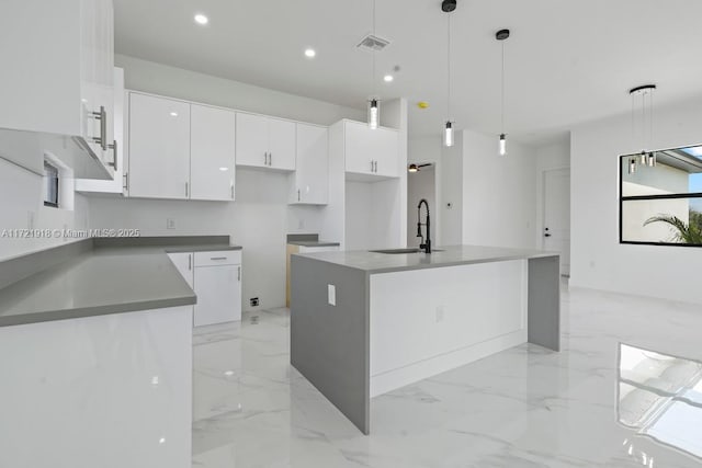 1608 Flora Ave S, Lehigh Acres, FL 33976 - kitchen featuring marble finish floor, visible vents, a kitchen island with sink, a sink, and white cabinetry