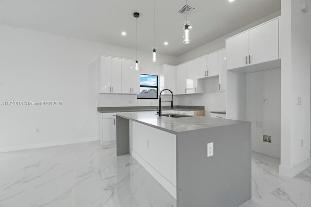 1608 Flora Ave S, Lehigh Acres, FL 33976 - kitchen with marble finish floor, a kitchen island with sink, a sink, and white cabinetry