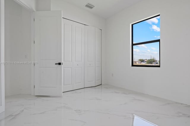 1608 Flora Ave S, Lehigh Acres, FL 33976 - unfurnished bedroom with marble finish floor, a closet, and visible vents