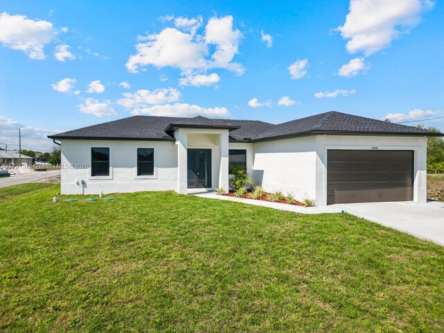 1608 Flora Ave S, Lehigh Acres, FL 33976 - prairie-style home featuring a shingled roof, concrete driveway, an attached garage, a front yard, and stucco siding