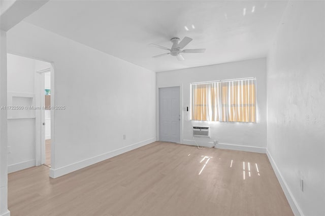 empty room with a wall mounted air conditioner, light wood-type flooring, and ceiling fan