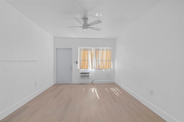 empty room featuring a wall mounted air conditioner, ceiling fan, and light wood-type flooring