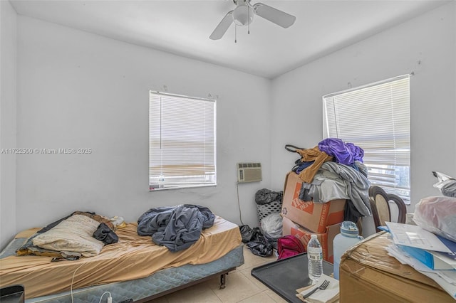 tiled bedroom featuring a wall mounted air conditioner and ceiling fan