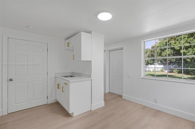 kitchen with white cabinets and light hardwood / wood-style flooring