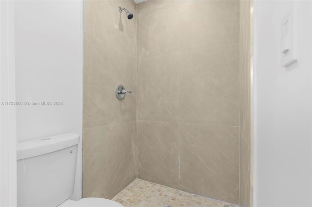 bathroom featuring tiled shower and toilet