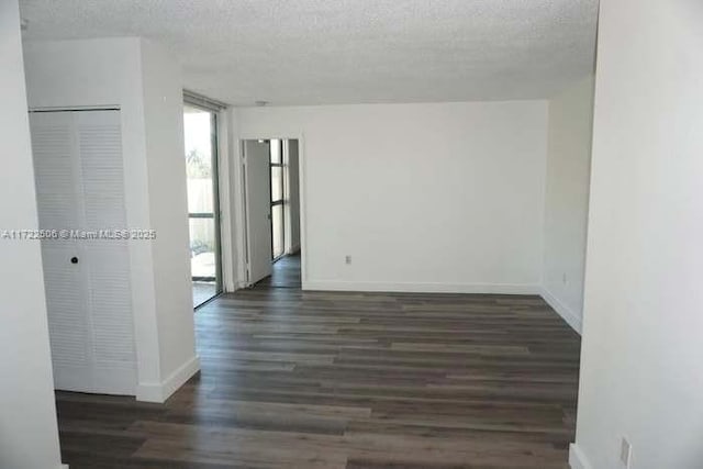 unfurnished room featuring baseboards, a textured ceiling, and wood finished floors
