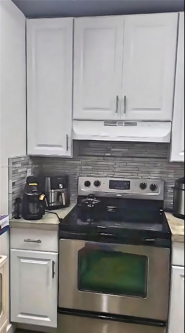 kitchen featuring light countertops, electric stove, white cabinetry, tasteful backsplash, and under cabinet range hood