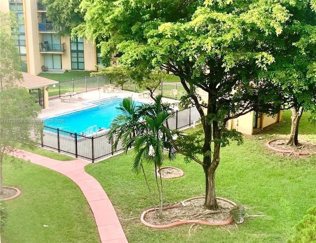 view of swimming pool featuring a yard