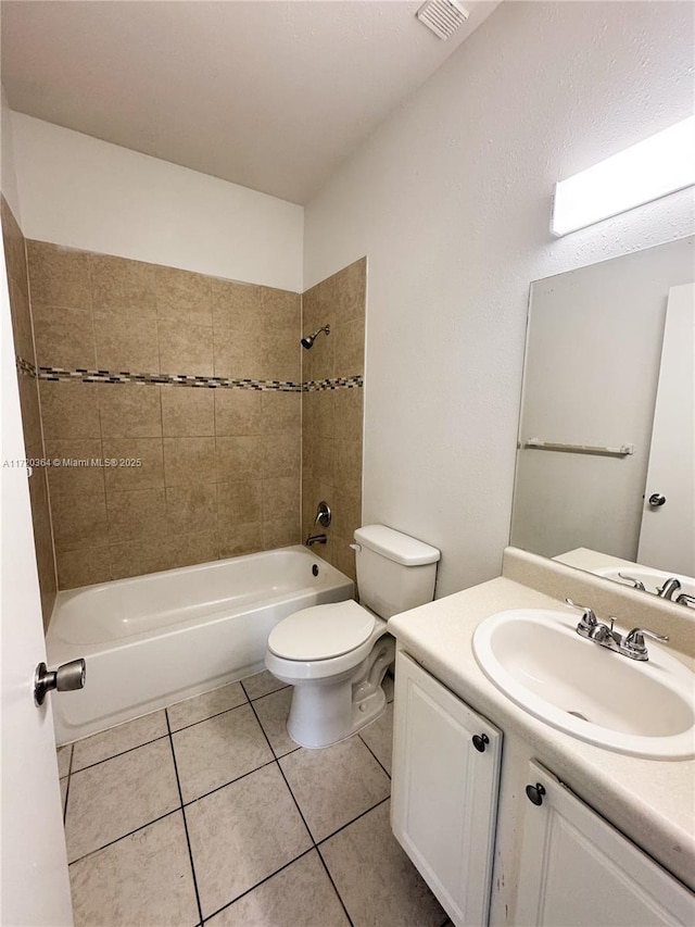 full bathroom with tile patterned floors, tiled shower / bath combo, toilet, and vanity