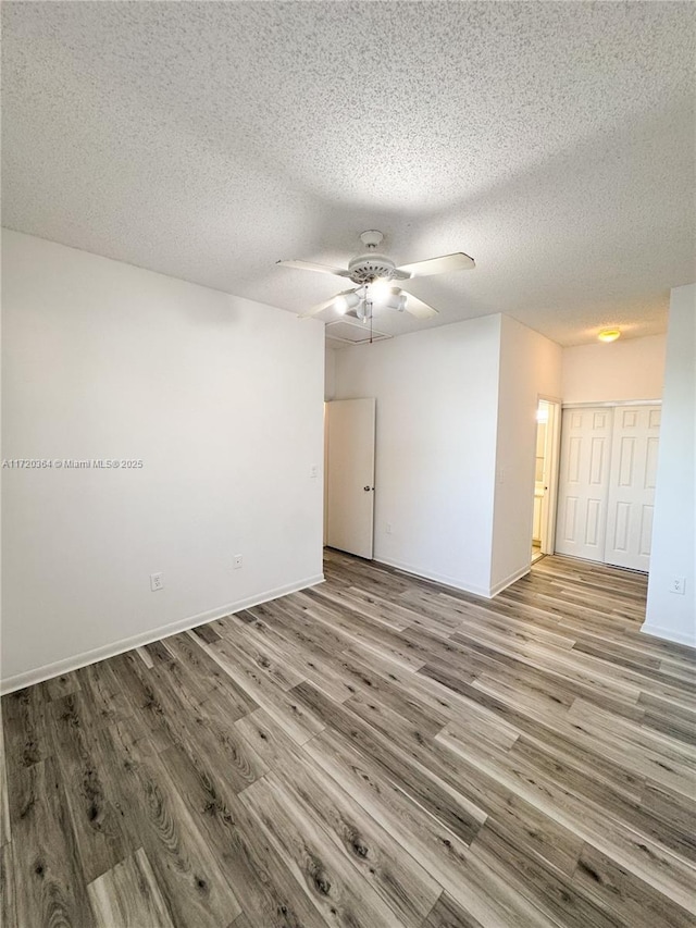 spare room with light hardwood / wood-style floors and a textured ceiling