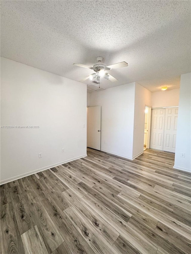 spare room with a textured ceiling, light hardwood / wood-style flooring, and ceiling fan