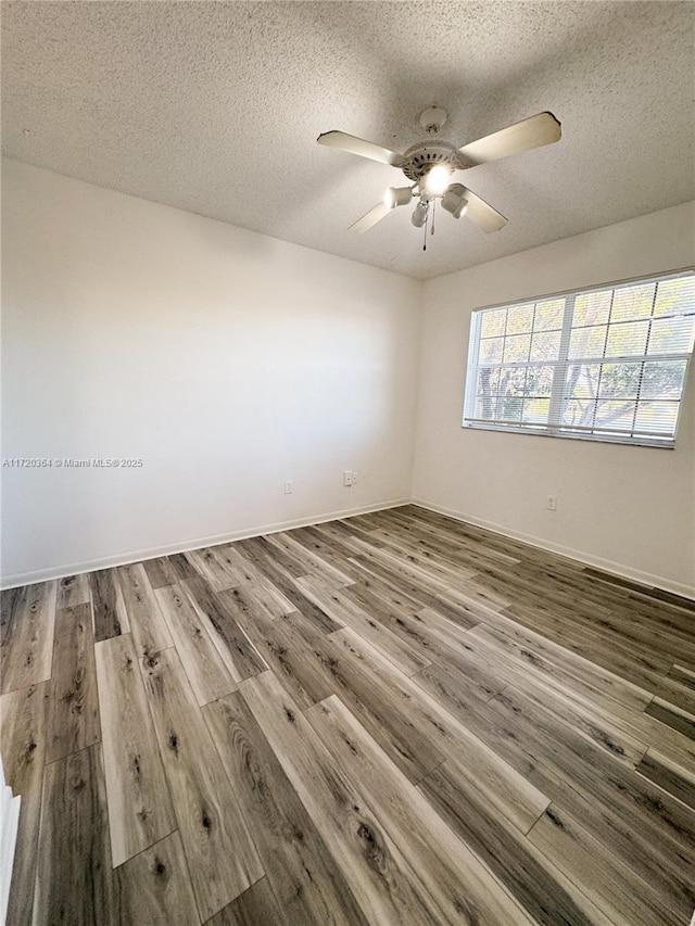 unfurnished room with ceiling fan, wood-type flooring, and a textured ceiling