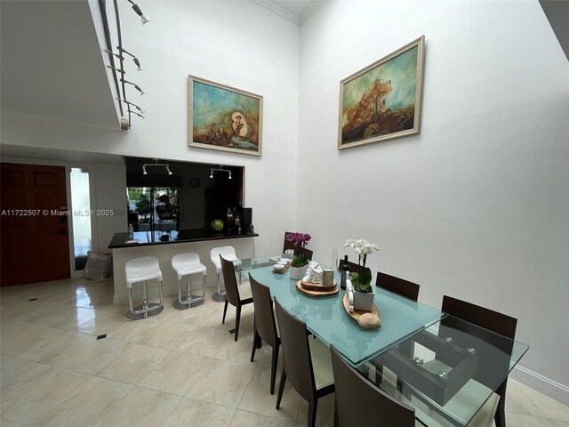 dining area featuring light tile patterned flooring and crown molding