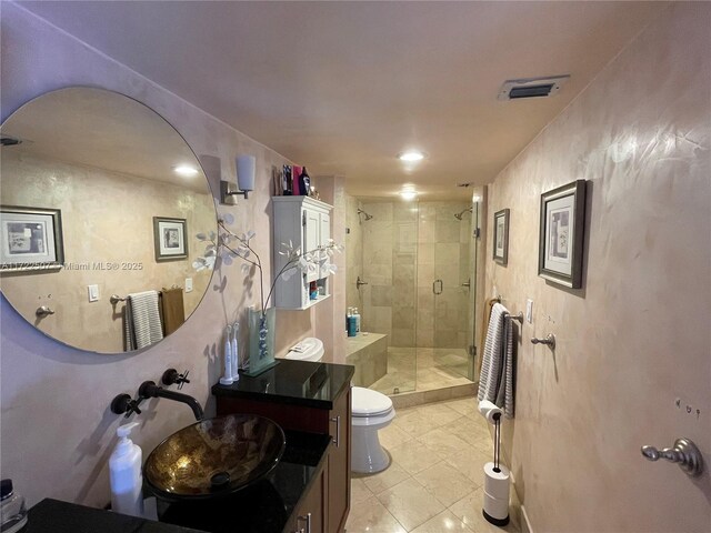 bathroom featuring tile patterned floors, vanity, toilet, and walk in shower