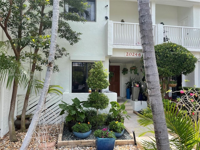 20246 NE 34th Ct Unit 46, Aventura, FL 33180 - doorway to property with stucco siding and a balcony