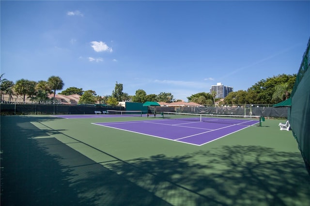 view of tennis court featuring fence and community basketball court