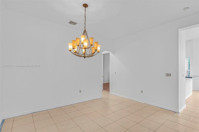 tiled empty room with a chandelier