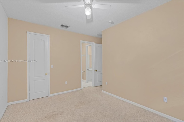 empty room with light carpet, a textured ceiling, and ceiling fan