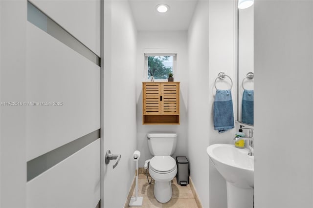 bathroom featuring tile patterned flooring, toilet, and sink