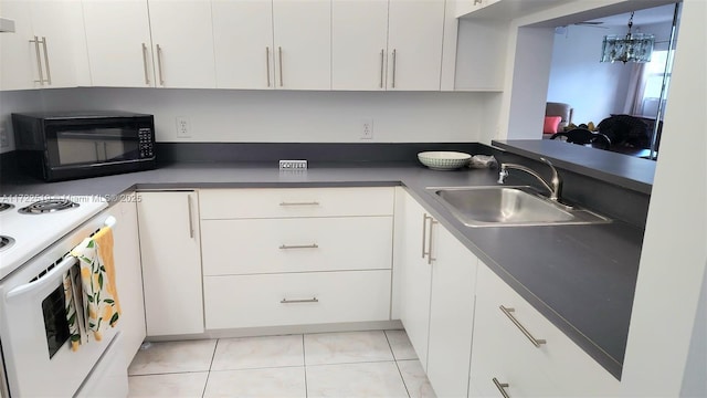 kitchen featuring white cabinets, light tile patterned floors, white range oven, and sink