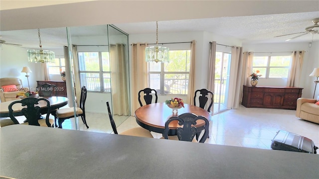 dining area with a textured ceiling and ceiling fan with notable chandelier