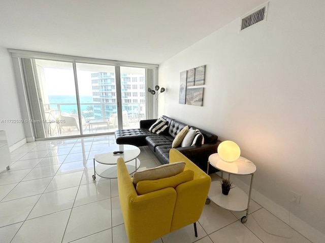 tiled living room with a water view and a wall of windows