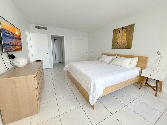 bedroom with light tile patterned floors and a closet