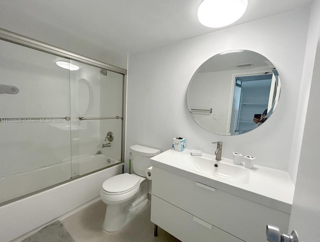 full bathroom with tile patterned floors, vanity, bath / shower combo with glass door, and toilet