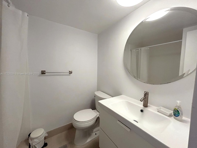 bathroom with curtained shower, vanity, and toilet