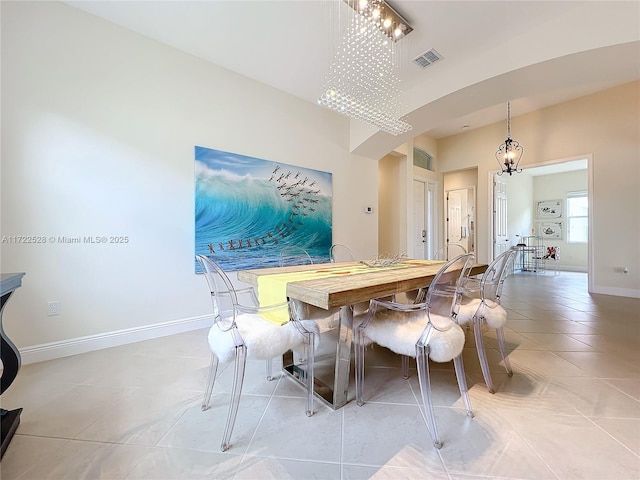 tiled dining area featuring a chandelier