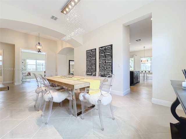 dining space featuring a notable chandelier, plenty of natural light, and light tile patterned floors