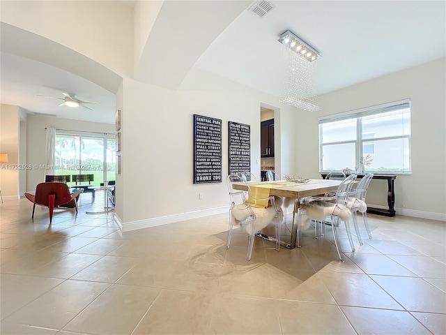 dining area with light tile patterned flooring and ceiling fan with notable chandelier