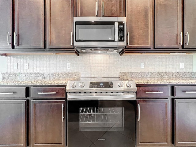 kitchen featuring tile patterned floors, light stone countertops, tasteful backsplash, dark brown cabinets, and stainless steel appliances