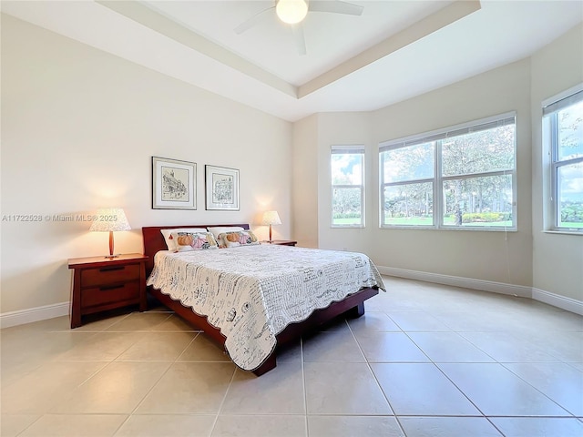 tiled bedroom featuring multiple windows, a tray ceiling, and ceiling fan