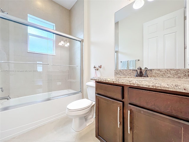 full bathroom featuring shower / bath combination with glass door, tile patterned flooring, vanity, and toilet