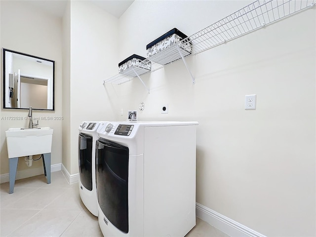 laundry area featuring light tile patterned floors and washer and clothes dryer